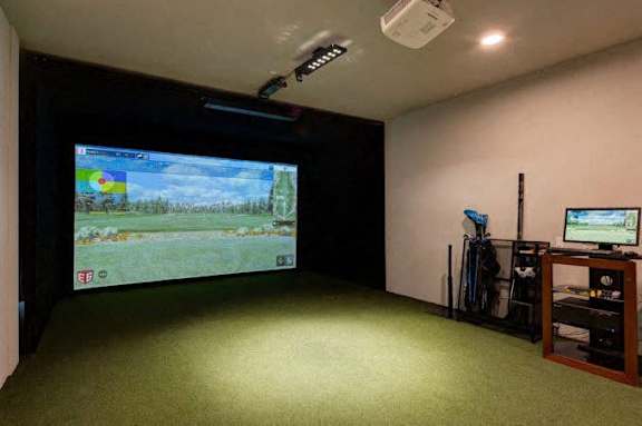 A room with a large screen and a smaller screen on a stand.