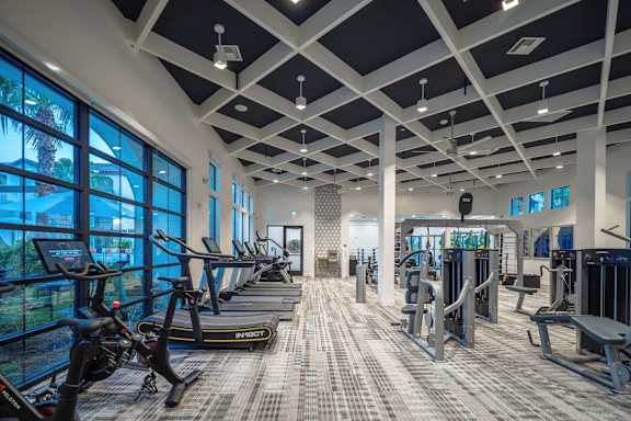 A gym with treadmills, exercise bikes, and other equipment.