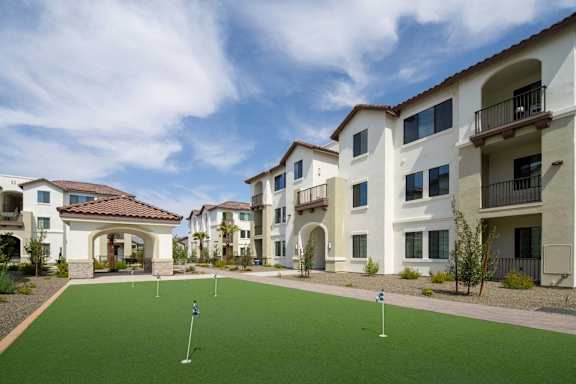 A golf course is located in front of apartment buildings.