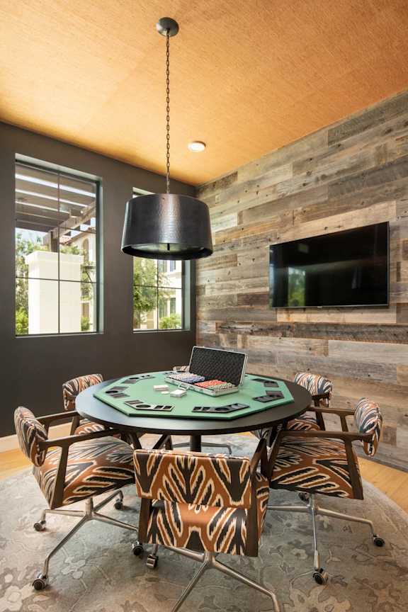 A room with a round table and chairs with a laptop on it.