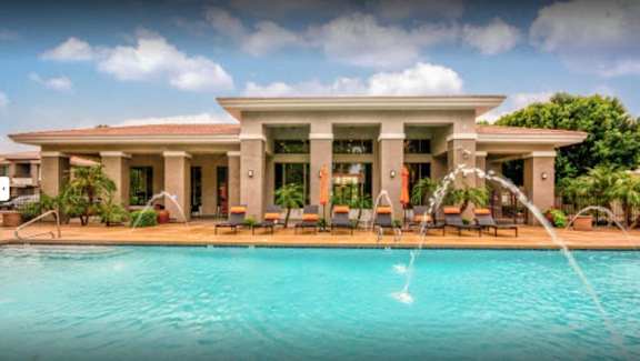 A large house with a pool in front.