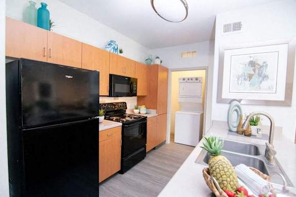 A kitchen with a black fridge, microwave, and oven.