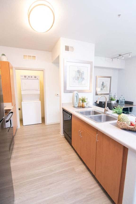 A kitchen with a sink, refrigerator, and oven.