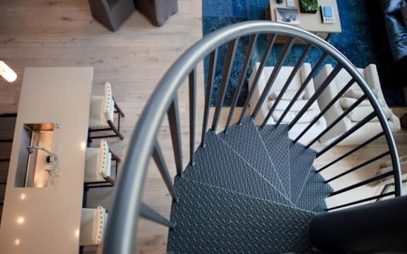 A chair with a metal frame and a grey seat is in the foreground of the image.