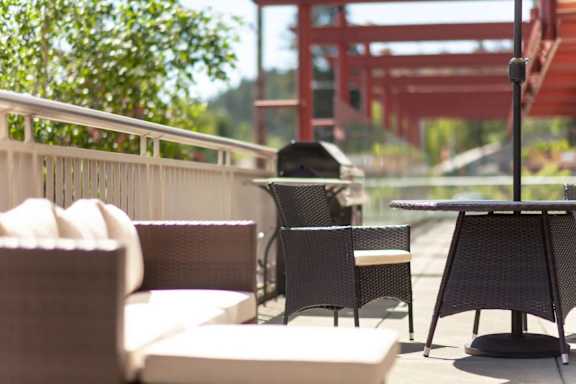 A patio with a table and chairs overlooking a bridge.