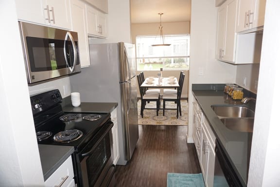 a kitchen with stainless steel appliances and a table with chairs
