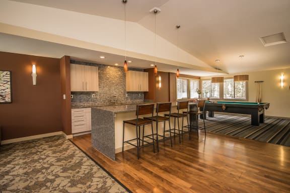an open living room with a bar and a pool table at Creekside Apartments, Washington, 98027