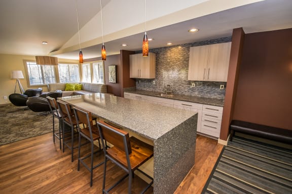 a kitchen with a marble counter top and a long island with chairs at Creekside Apartments, Issaquah, WA, 98027