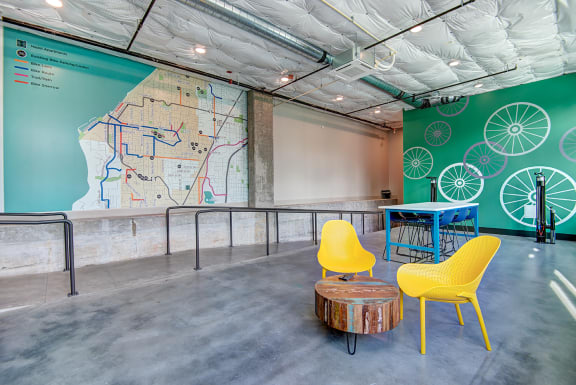 a room with yellow chairs and a table and a map on the wall at Hazel Apartments, Edmonds, 98026