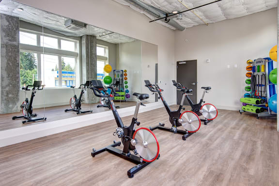 a fitness room with exercise bikes and weights at the belgard apartments at Hazel Apartments, Washington