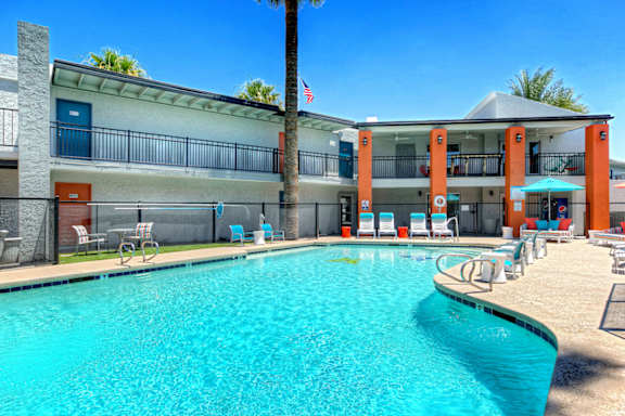 A swimming pool in front of a building with a flag on it.