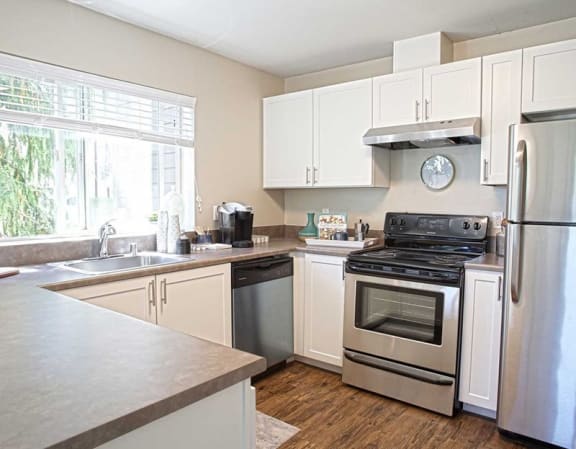 a kitchen with stainless steel appliances and white cabinets