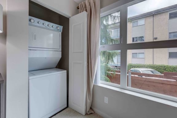a white washer and dryer in a room next to a window