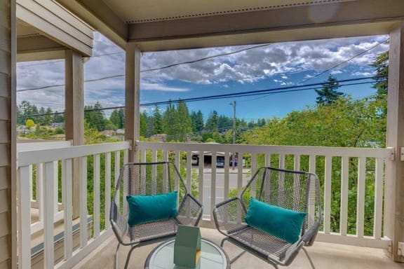 a patio with two chairs and a table on a balcony