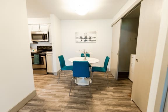 a dining room with a table and chairs and a kitchen at Aero Apartments, Washington, 98444