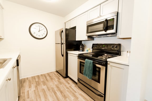 a kitchen with stainless steel appliances and a clock on the wall at Aero Apartments, Tacoma, WA