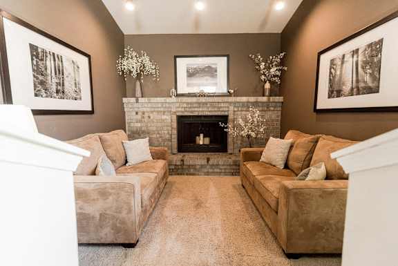 a living room with a fireplace and couches at Cambridge on Seventh, Puyallup