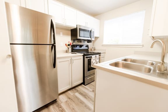 a kitchen with stainless steel appliances and white cabinets&#xA0;at Cambridge on Seventh, Puyallup