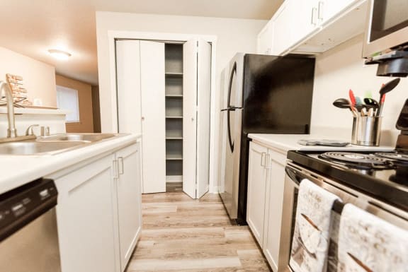 a kitchen with white cabinets and a stove and a refrigerator&#xA0;at Cambridge on Seventh, Washington