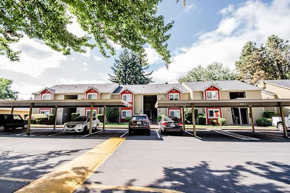 an apartment building with cars parked in a parking lot at Cambridge on Seventh, Puyallup, WA, 98372