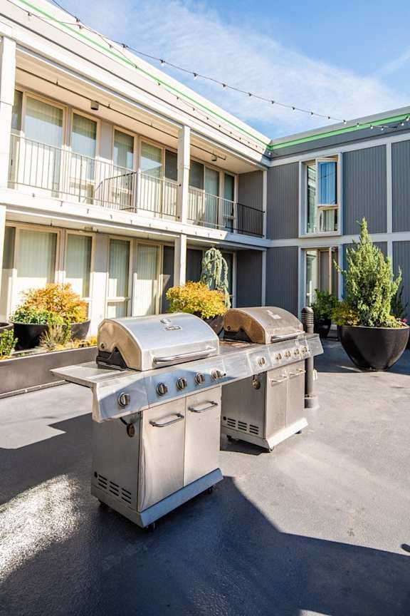 two stainless steel barbecue grills in front of a building at Cosmopolitan, Seattle, WA