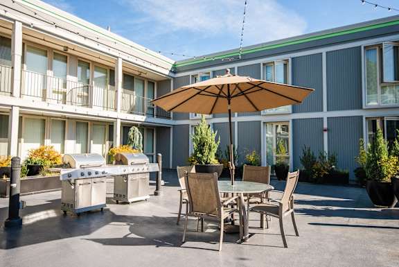 a patio with tables and chairs and an umbrella at Cosmopolitan, Washington, 98105