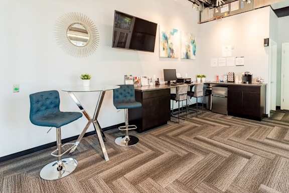 a communal area with a table and chairs and a kitchen with a sink at Cosmopolitan, Seattle, WA, 98105