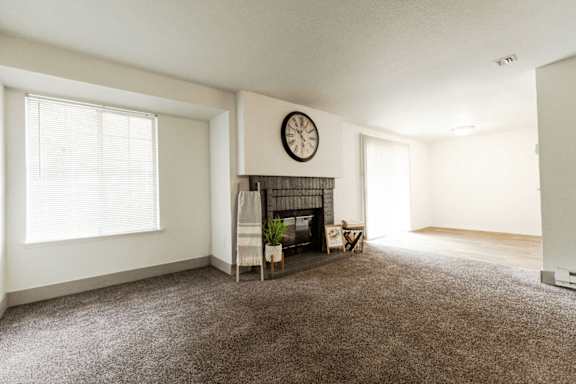 A room with a fireplace and a clock on the wall. at Crown Pointe, Lakewood, WA, 98499