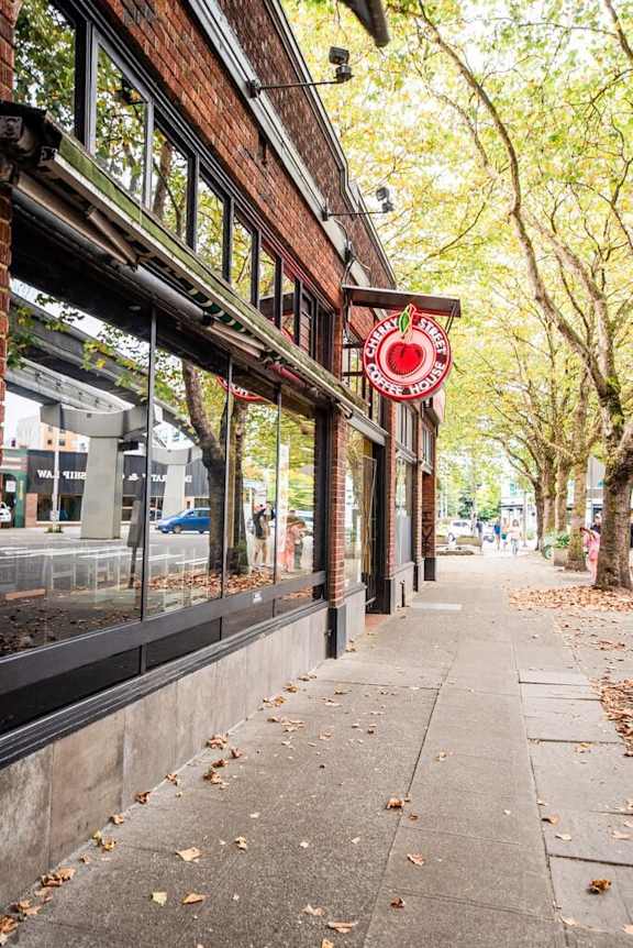 A red sign with a white apple on it is on the side of a building. at Edwards on Fifth, Seattle, WA