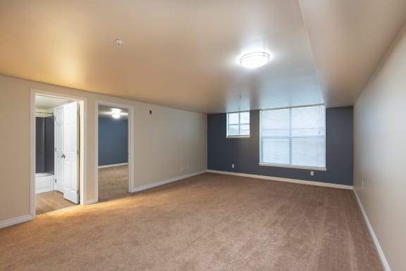 an empty living room with blue walls and a window