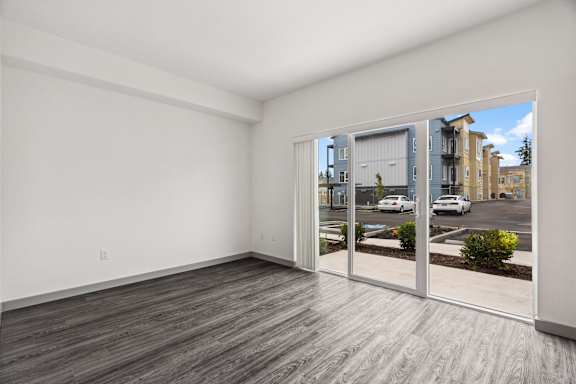 A room with a sliding glass door leading to a parking lot.