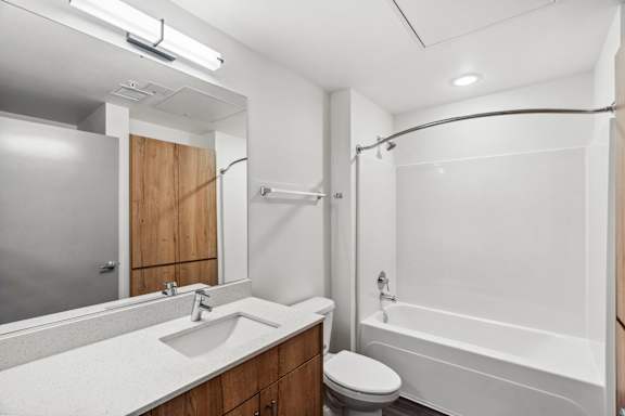 A white bathroom with a sink, toilet, and bathtub.