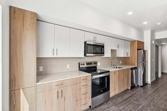 A modern kitchen with wooden cabinets and stainless steel appliances.