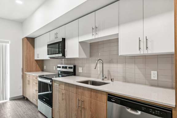 A modern kitchen with wooden cabinets and stainless steel appliances.