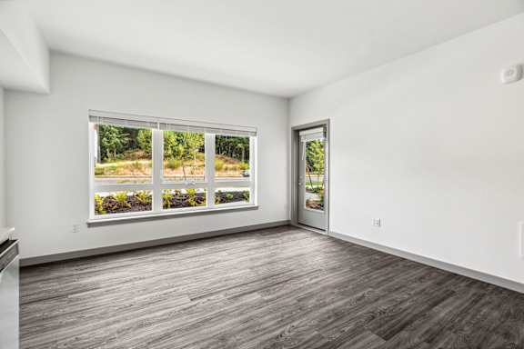 A room with a large window and a wooden floor.