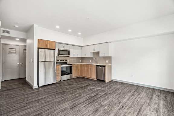 A modern kitchen with wooden floors and white walls.