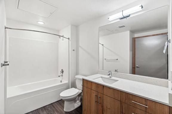 A white bathroom with a toilet, sink, and bathtub.