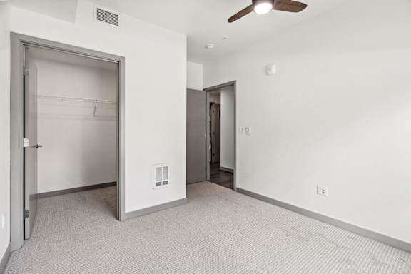 A room with a ceiling fan and two doors.