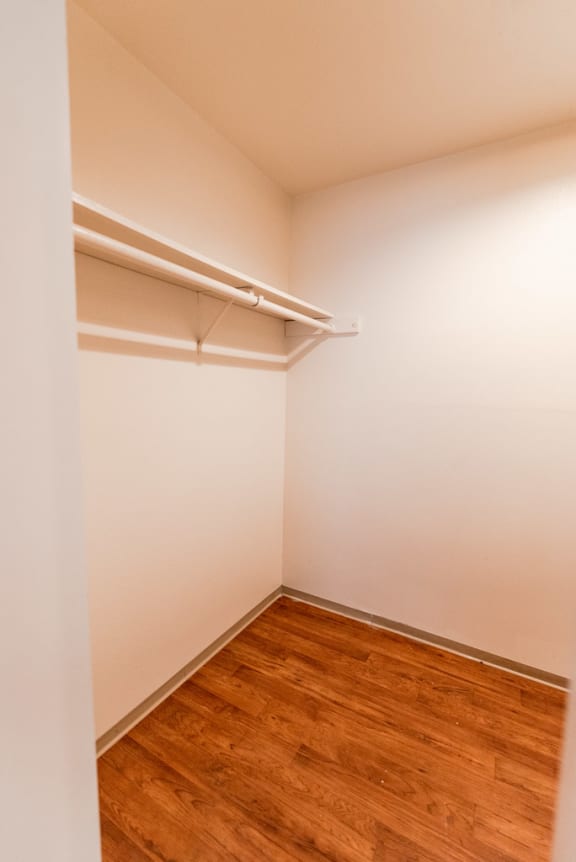 an empty room with a white wall and a wooden floor