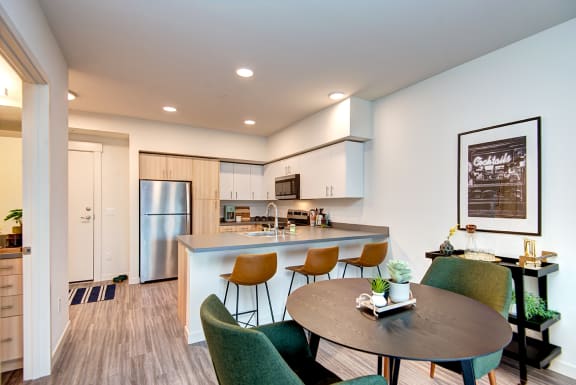 an open kitchen and dining area with a table and chairs at Hazel Apartments, Edmonds, WA, 98026