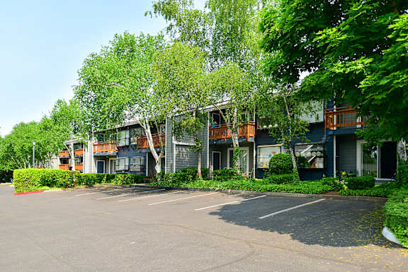 an empty parking lot in front of apartment buildings