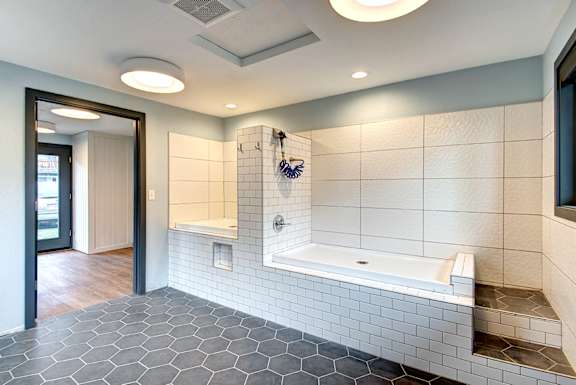 a large white bathroom with a tub and a shower