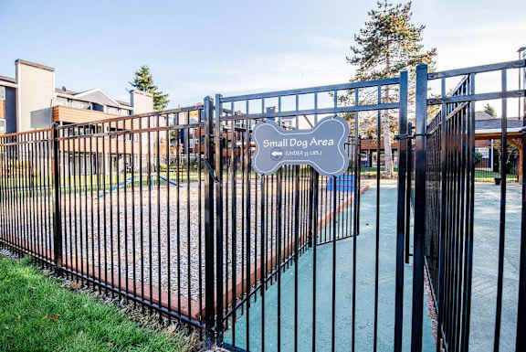 A black fence surrounds a small dog area. at Northpoint Apartments, Tacoma, Washington