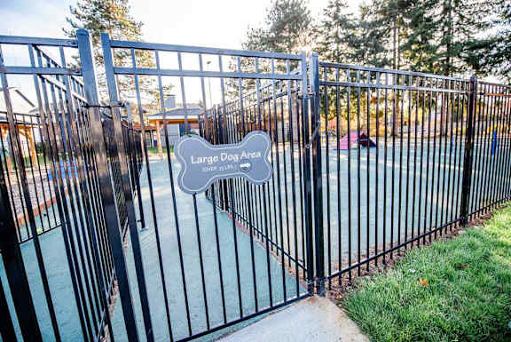 A black metal gate with a sign that says Large Dog Area. at Northpoint Apartments, Washington, 98407