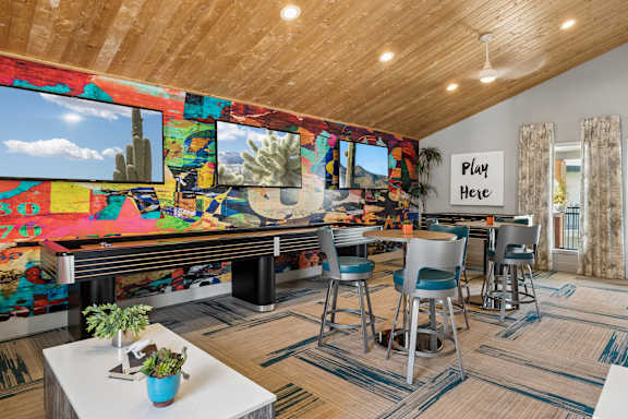 A room with a pool table and a sign that says "Play Here".