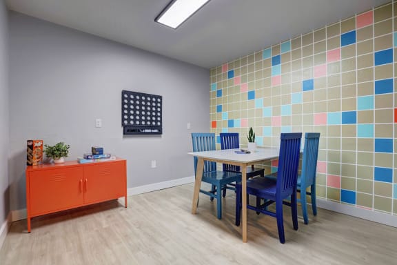 a dining room with a table and chairs and colorful tiles on the wall