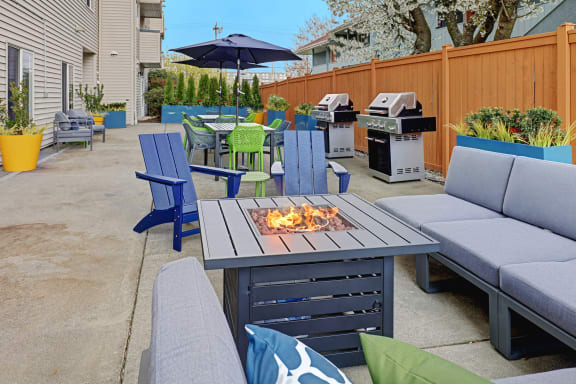 a patio with a fire pit and chairs and tables