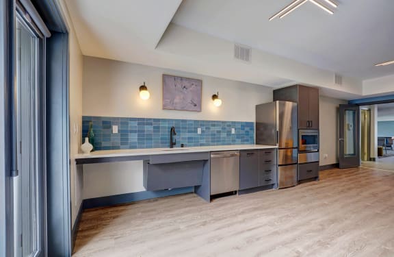 a kitchen with blue tiles and stainless steel appliances