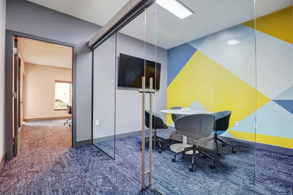 a meeting room with a table and chair and a tv