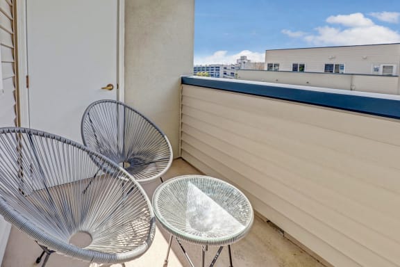 a private balcony with two chairs and a table